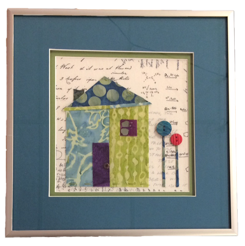 Picture of a house with trees made from material, quitled, appliqued, and framed