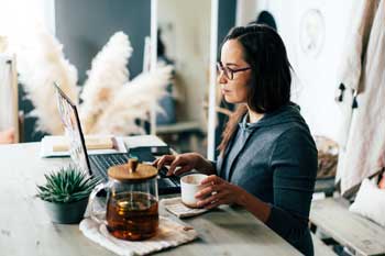 Picture of a lady at home using a computer to shop